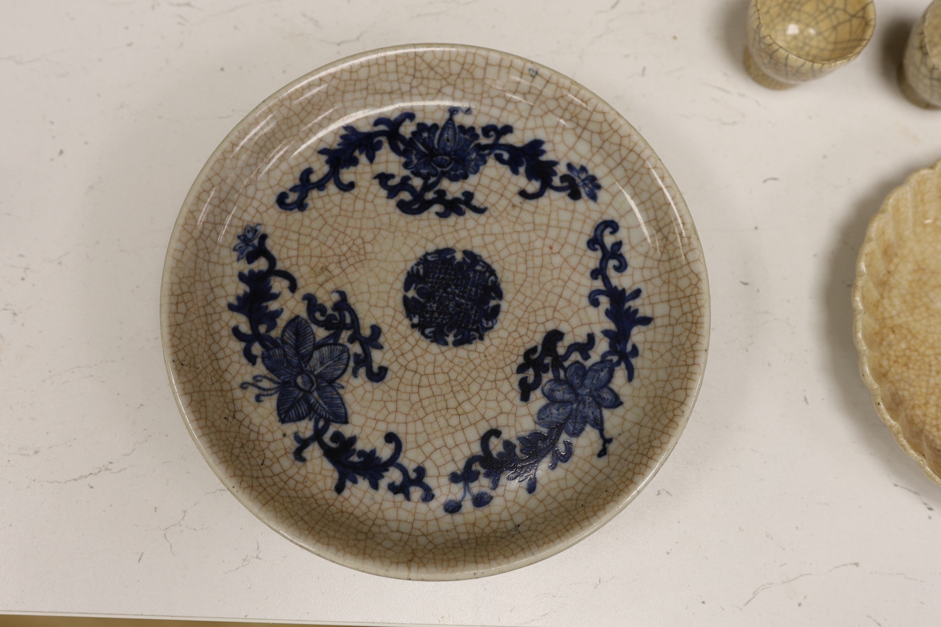 A Chinese crackle glaze chrysanthemum shaped dish, two cups and an underglaze blue dish, 19th century and later, blue dish 21cm diameter (4). Condition - fair